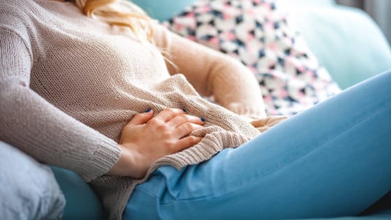 woman holding her abdomen in pain